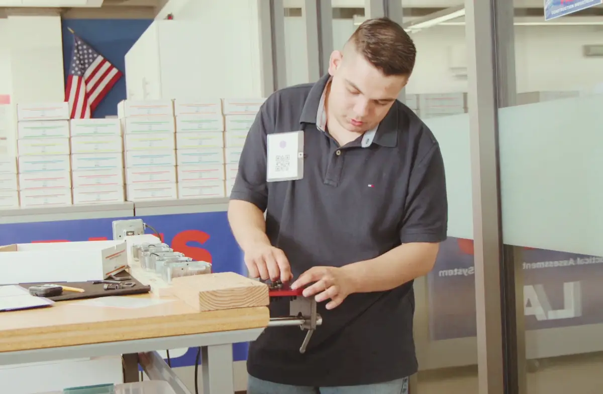 PAES Lab employee using a vise at the heavy-duty workbench